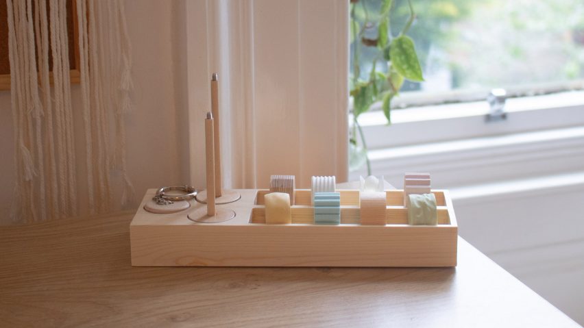 A photograph displaying a product on a table that aids people with ADHD, it features beige coloured wood and different colours of blue, yellow, pink and green.