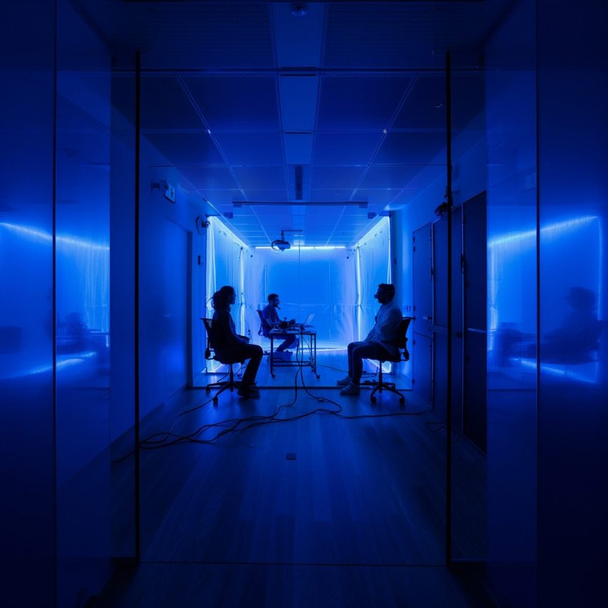 A photograph in tones of blue, displaying silhouettes of three people sat on chairs.