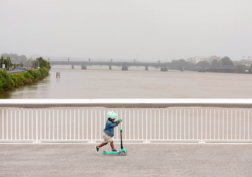 Boy on scooter over bridge