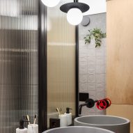 Grey basins with red legs and reeded glass panels in bathroom