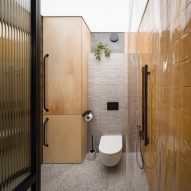 Bathroom with yellow walls and plywood cabinets