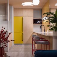 Plywood and concrete kitchen with yellow cabinets