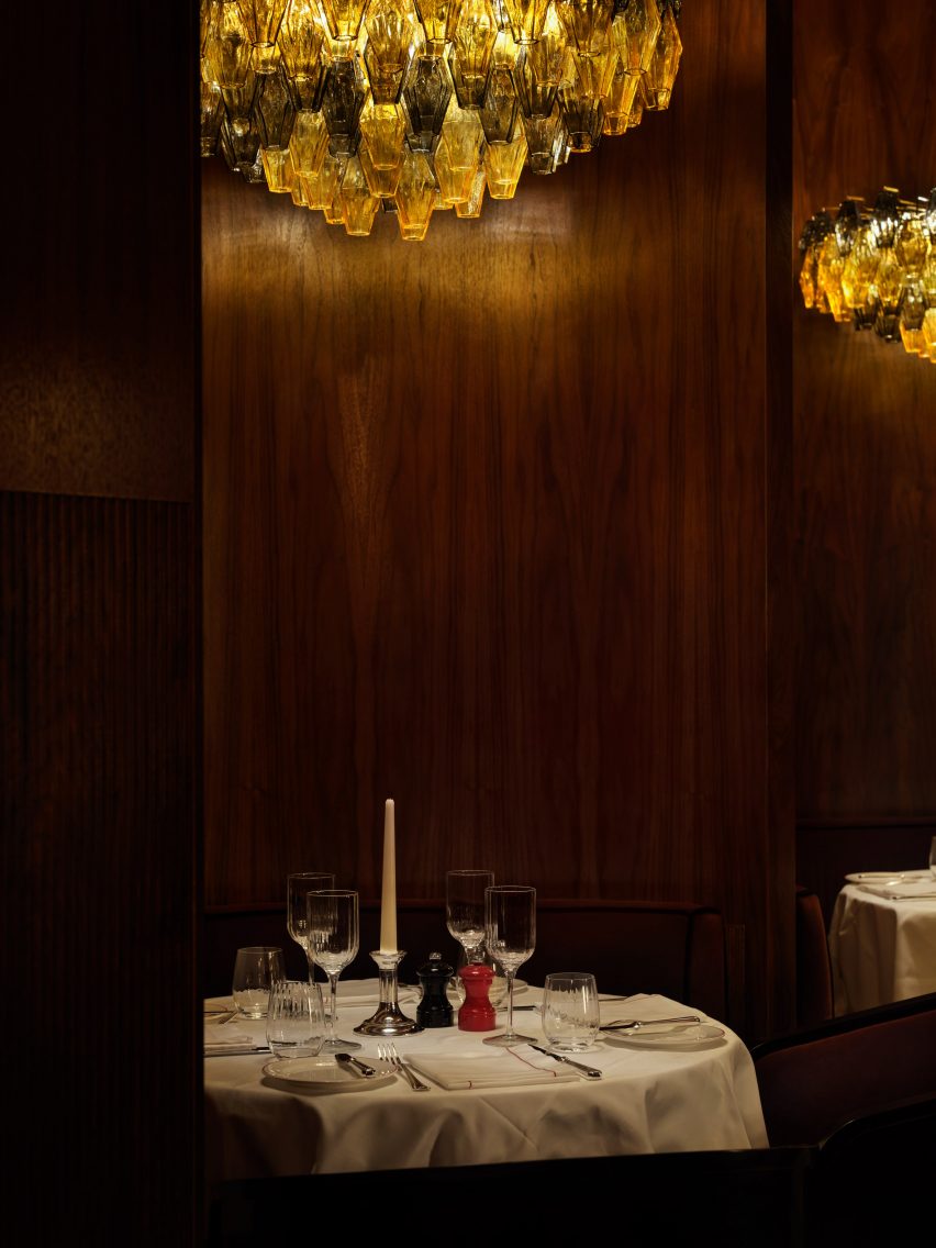 Curved dining booths feature Murano glass chandeliers