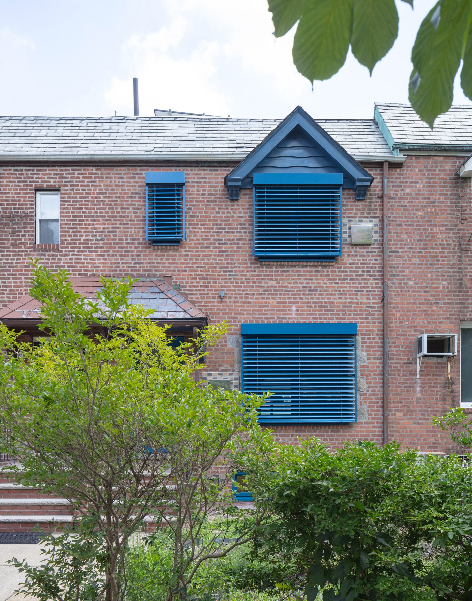 Terraced house with bright blue Venetian blinds over windows