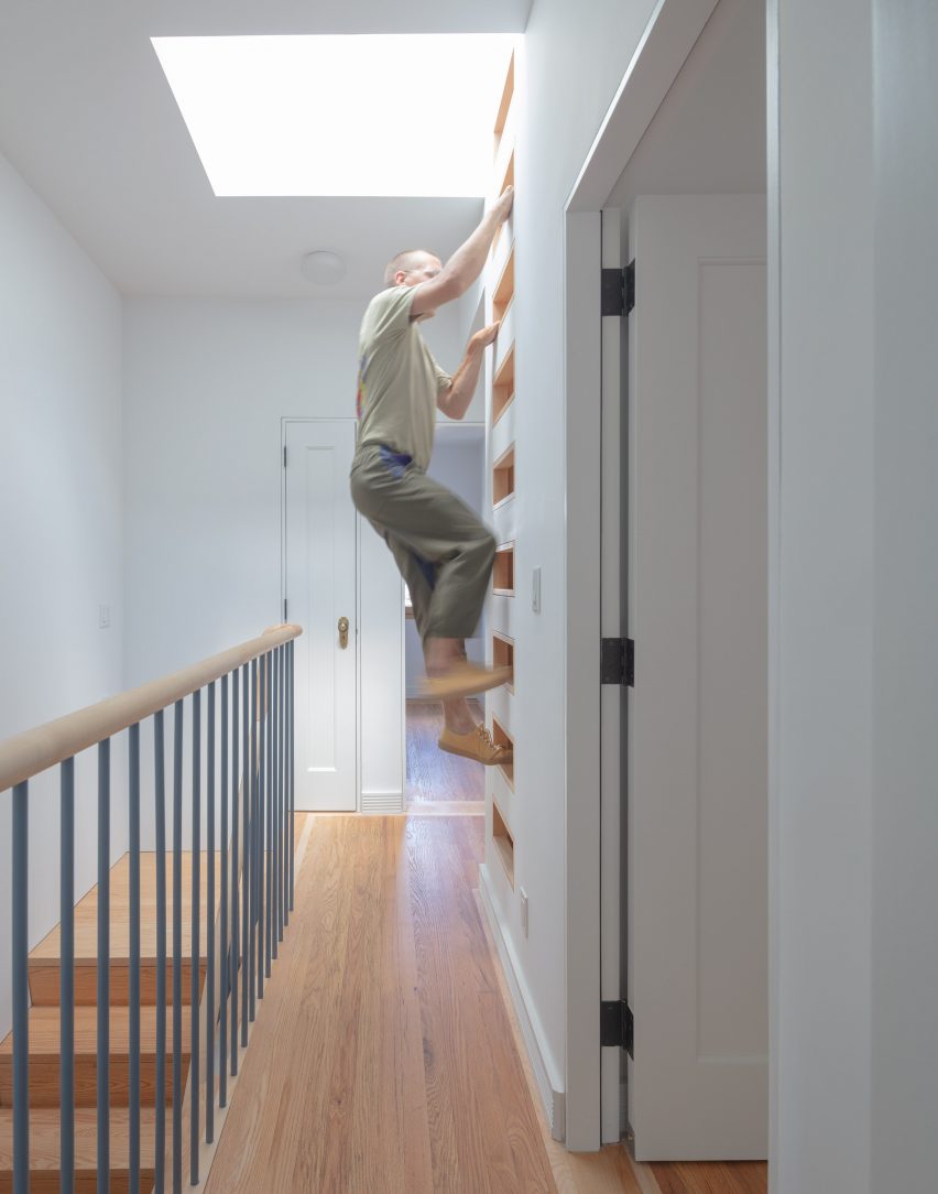 Man climbing a built-in ladder that provides roof access via a skylight