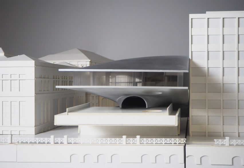 A photograph of an architectural model in tones of grey and white.