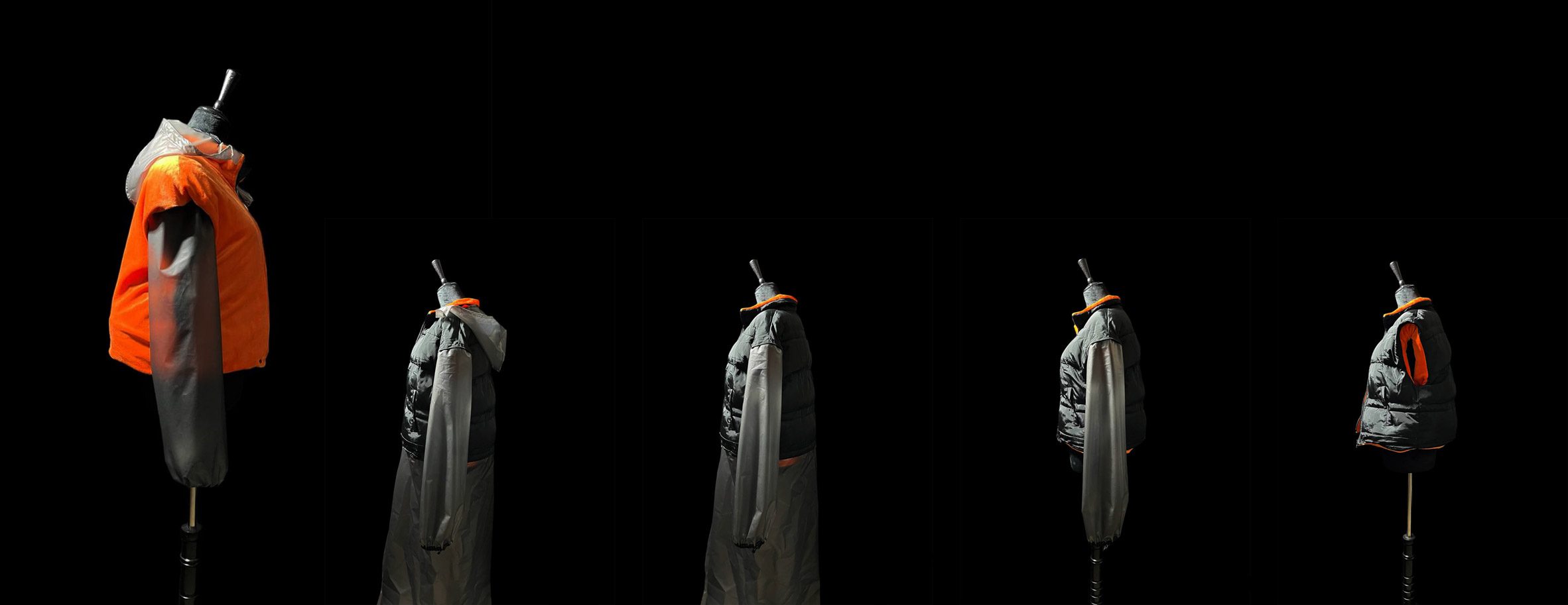 A photograph of five mannequins beside one another wearing garments in tones of grey and orange, against a black background.