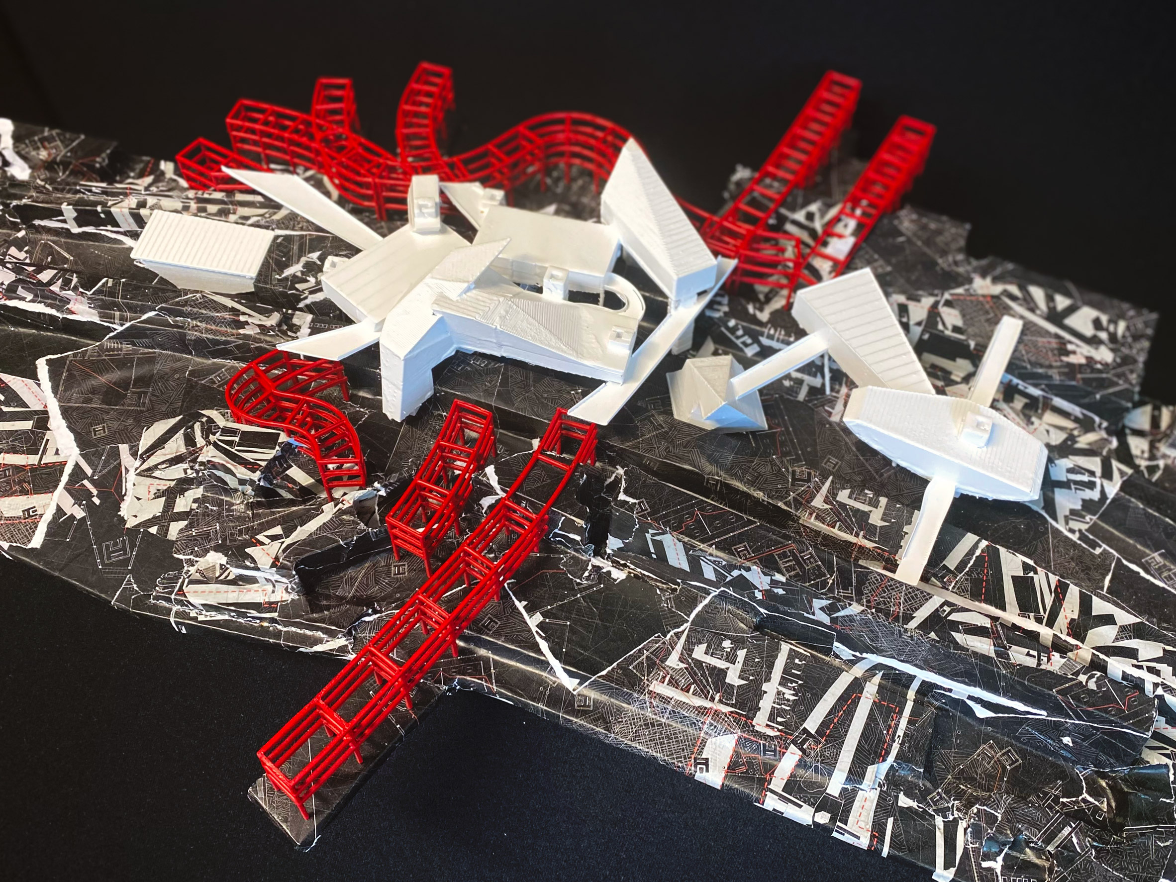 A photograph from above of an architectural model in colours of black, white and red.