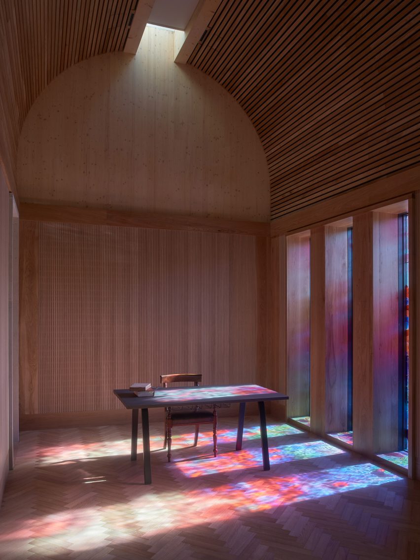 Wood-lined room lit by stained glass