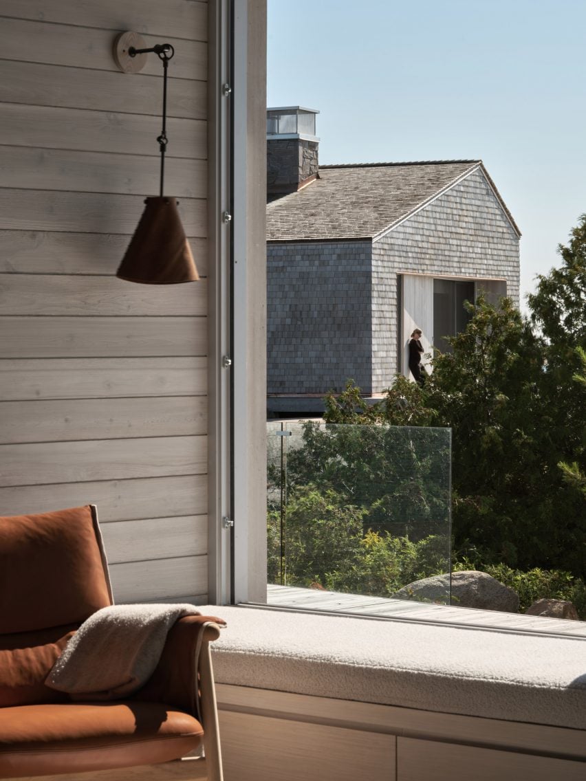 Window seat overlooking a planted area and a cabin beyond