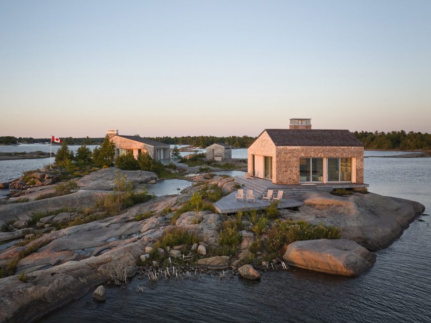 Cluster of small buildings on a rocky island at sunset