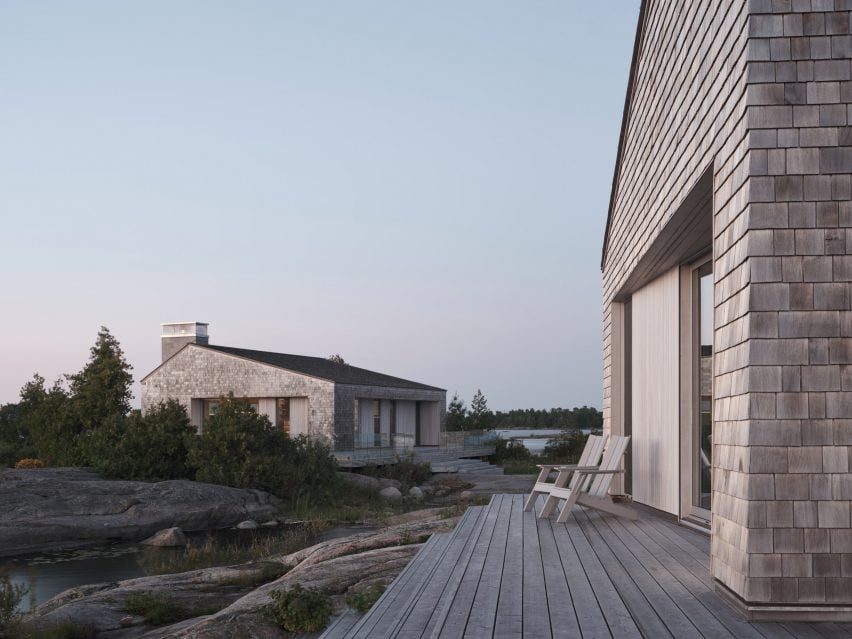 Two shingle-clad buildings with gabled roofs, surrounded by wooden decks