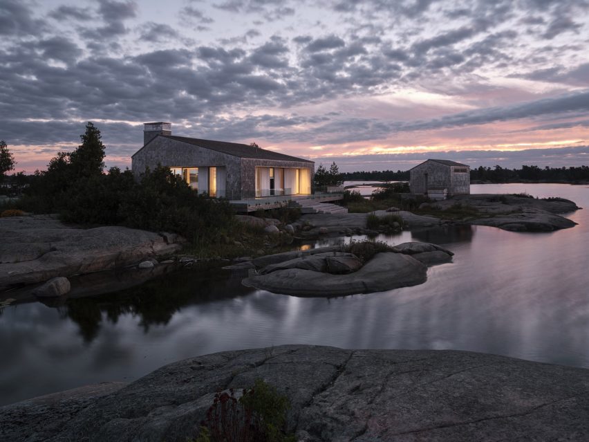 Cottages overlooking the water with late sunset behind