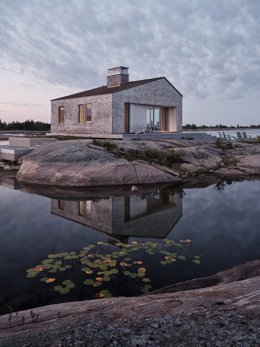 Shingle-clad building on a rocky outcrop surrounded by water