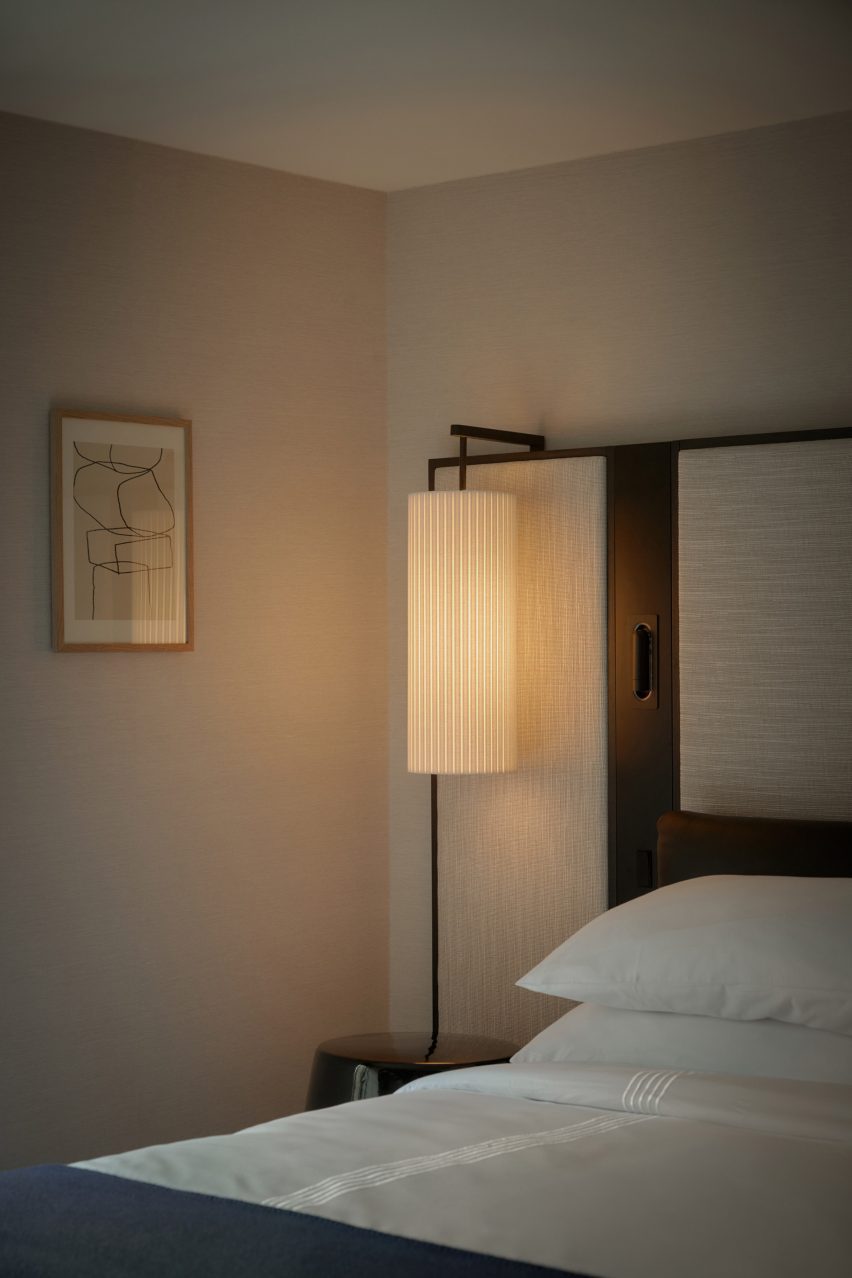 Bedroom with oversized fabric-upholstered headboard and textured wallpaper