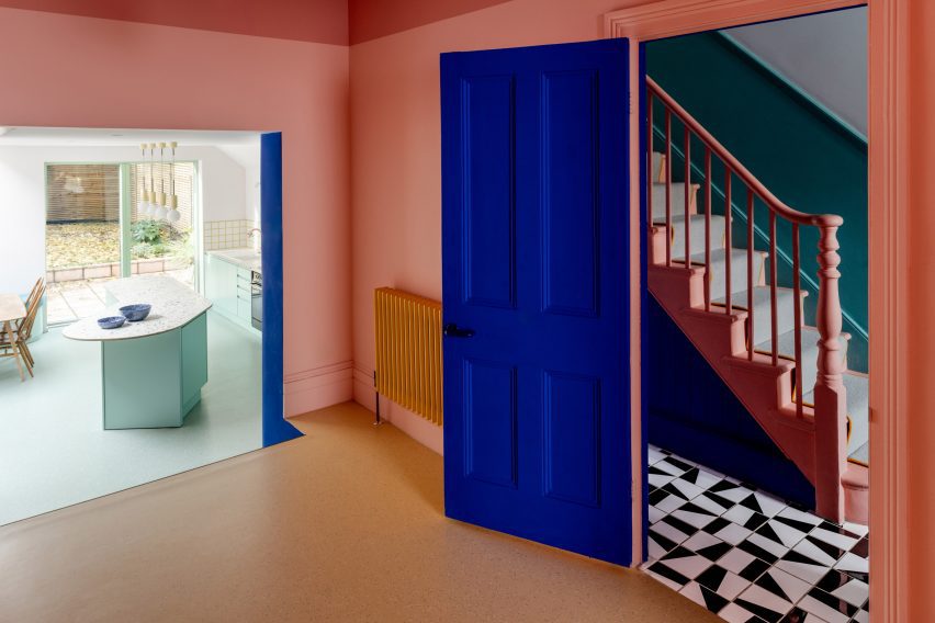 Hallway with monochrome floor tiles and pink banister