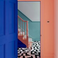 Hallway with monochrome floor tiles and pink banister