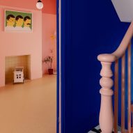 Hallway with monochrome floor tiles and pink banister