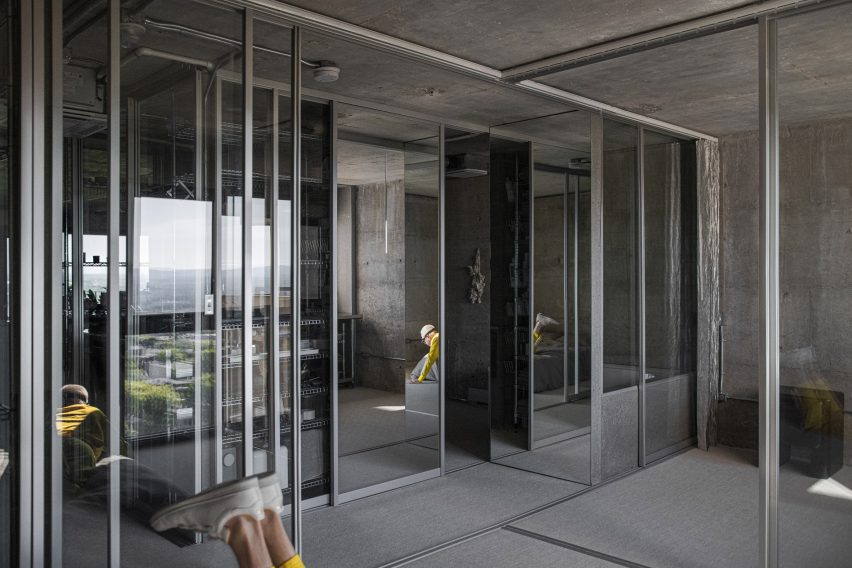 Glass partitions with partial reflections of a man in a yellow tracksuit