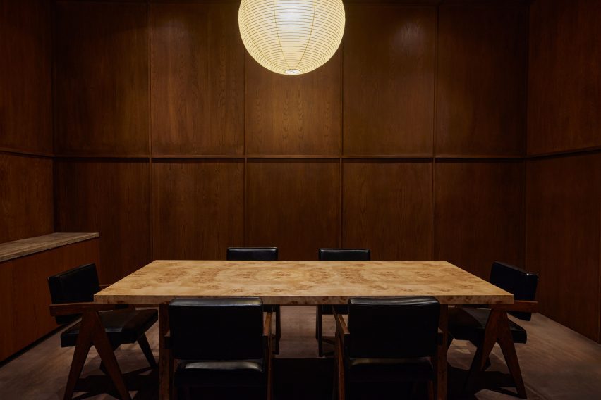 Maple-panelled conference room furnished with a burl wood table and Pierre Jeanneret chairs