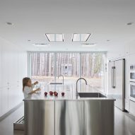 A kid in a kitchen with a metal island