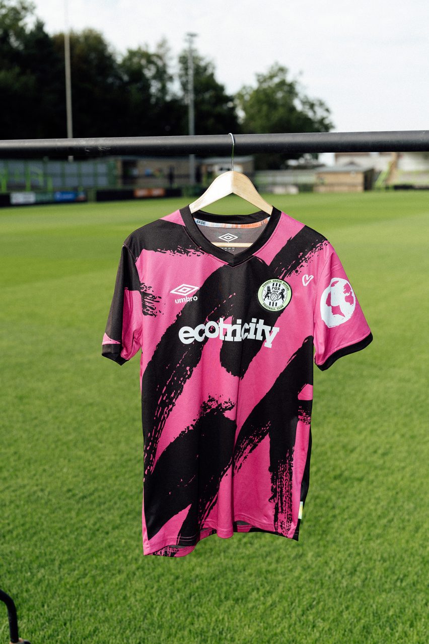 Pink football shirt on hanger above grass pitch