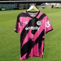 Pink football shirt on hanger above grass pitch