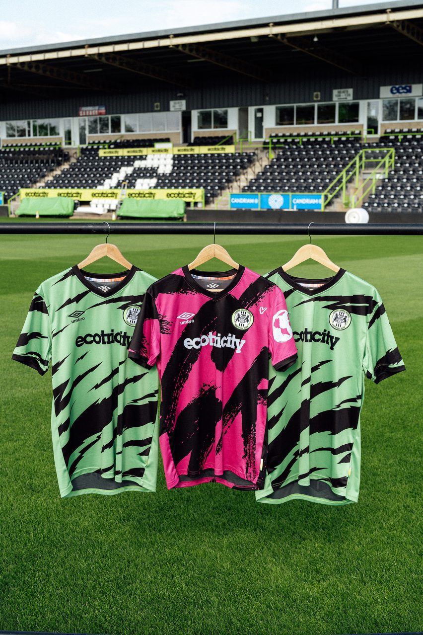 Pink and green football shirts on hangers above grass pitch