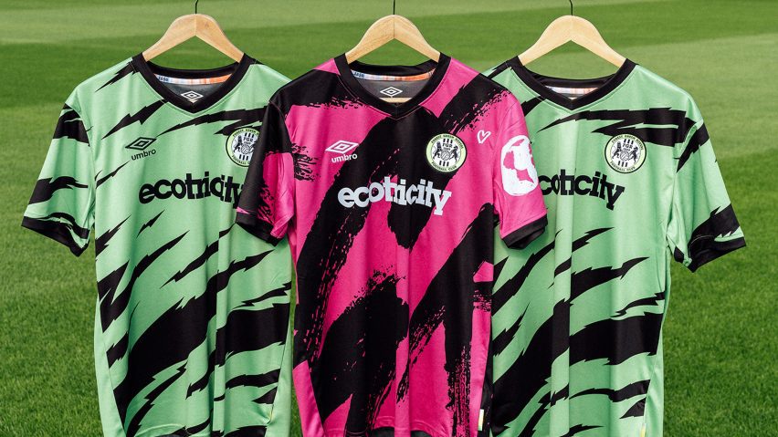 Pink and green football shirts on hangers above grass pitch