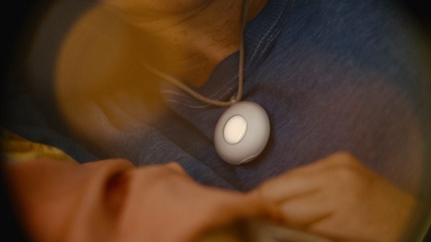 Close-up photo of the Friend necklace showing smooth rounded white casing with a lit-up centre