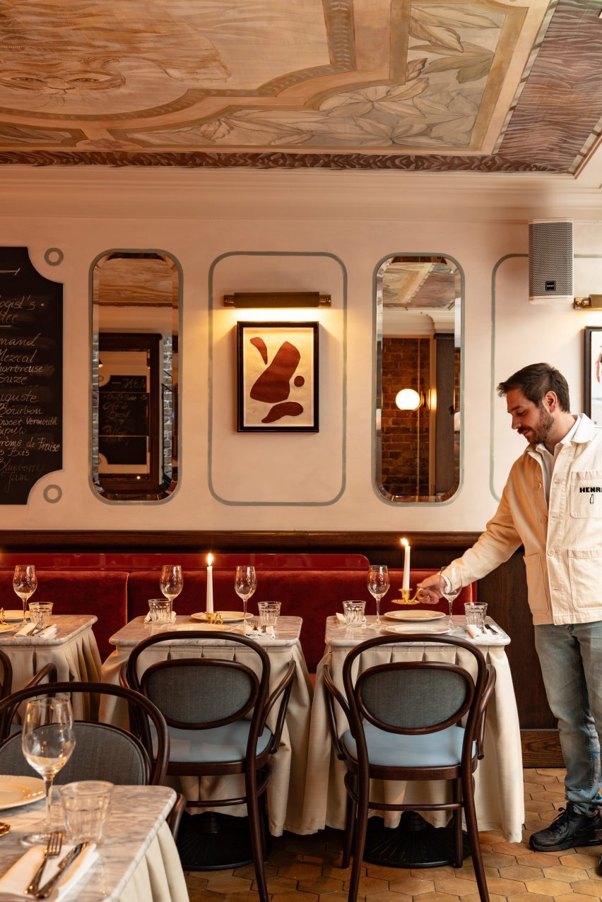 Waiter carrying a candle inside Henri restaurant 