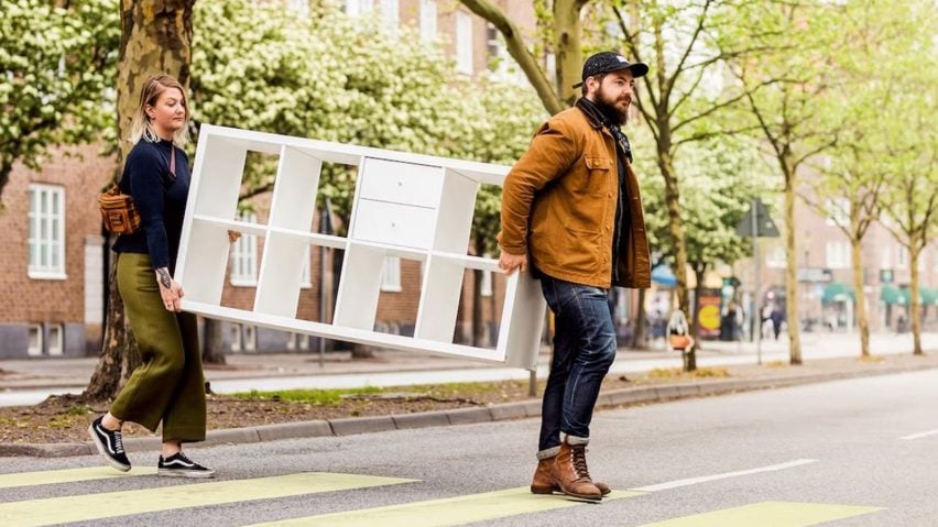 Two people carrying an IKEA cupboard