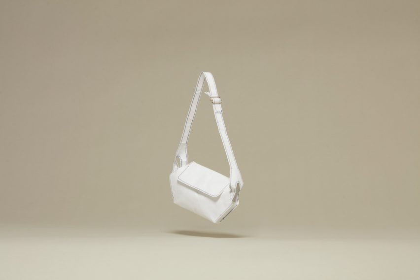 A white handbag against a beige backdrop.