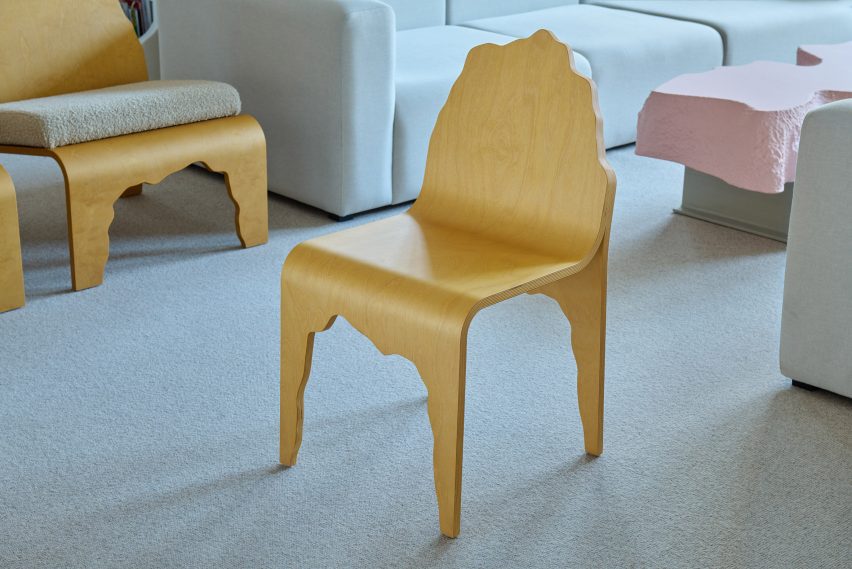 Wooden chair with wavy cutouts around the legs and back