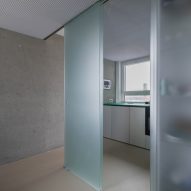 View from bathroom into kitchen through glass sliding doors