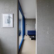 View into living area with blue sofa and blue window frame