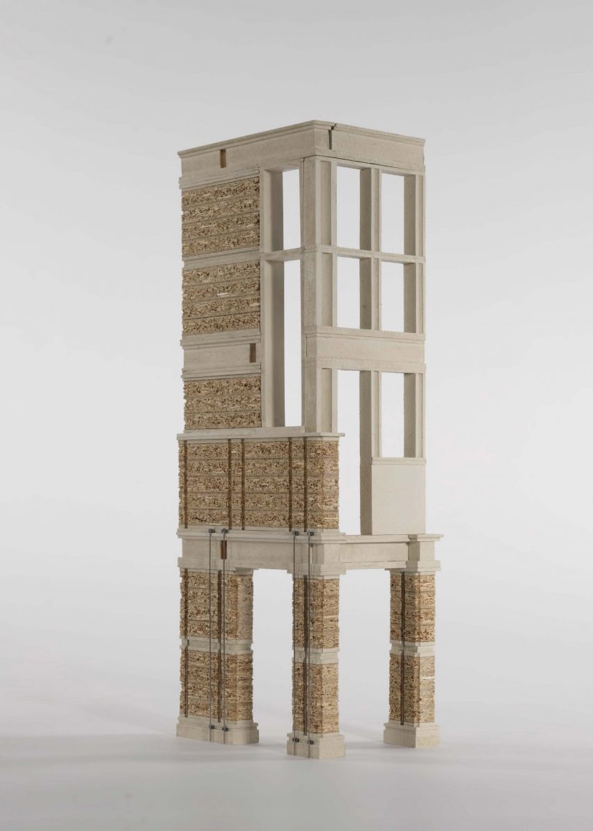 A photograph of an architectural model of a brick building structure agaisnt a white backdrop.