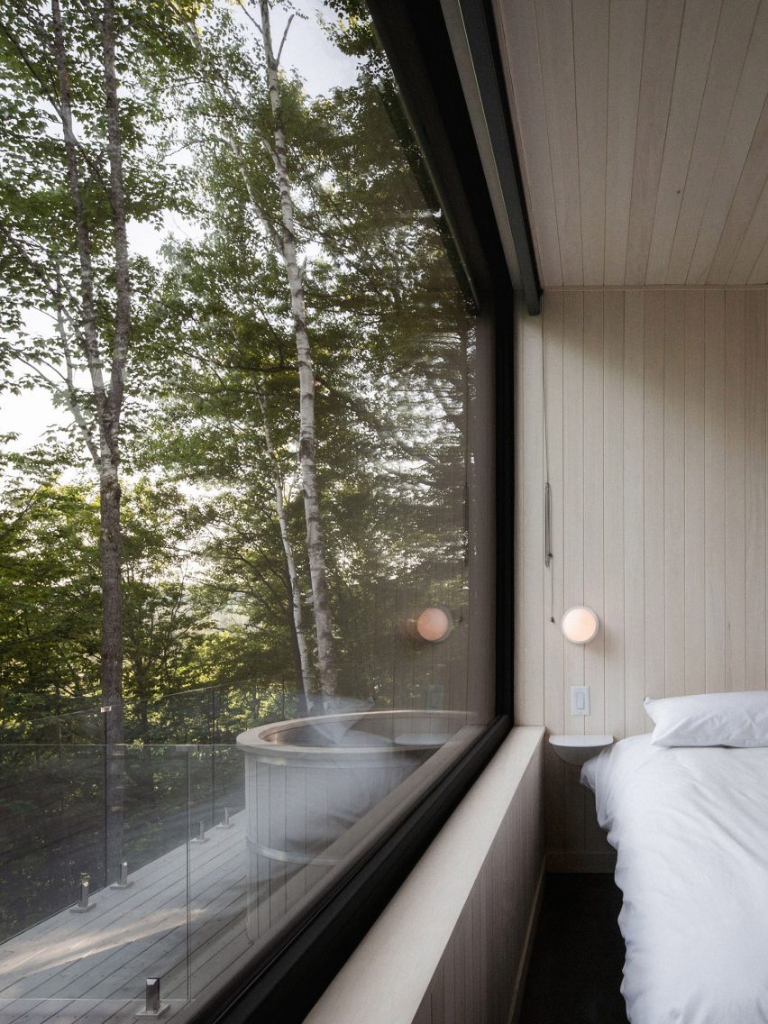 Bedroom with windows overlooking forest