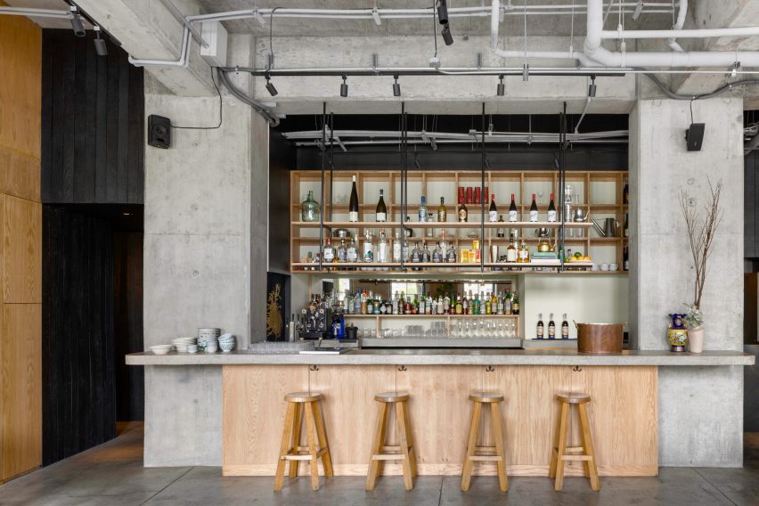 Bar with stools in front and open shelving suspended above