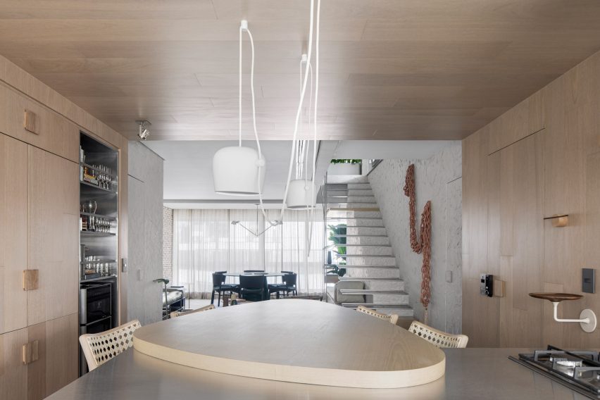 Kitchen island in front of a wood-lined arrival area