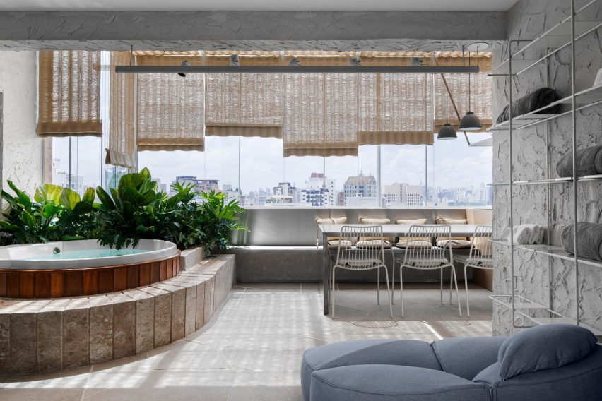 Glass-enclosed balcony with a hot tub and a dining area