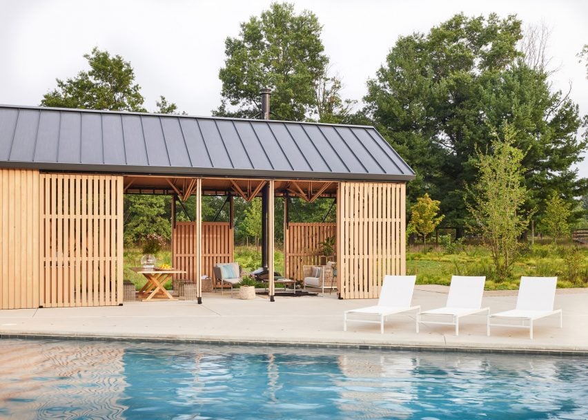 Pool house with sliding slatted panels on the long facades