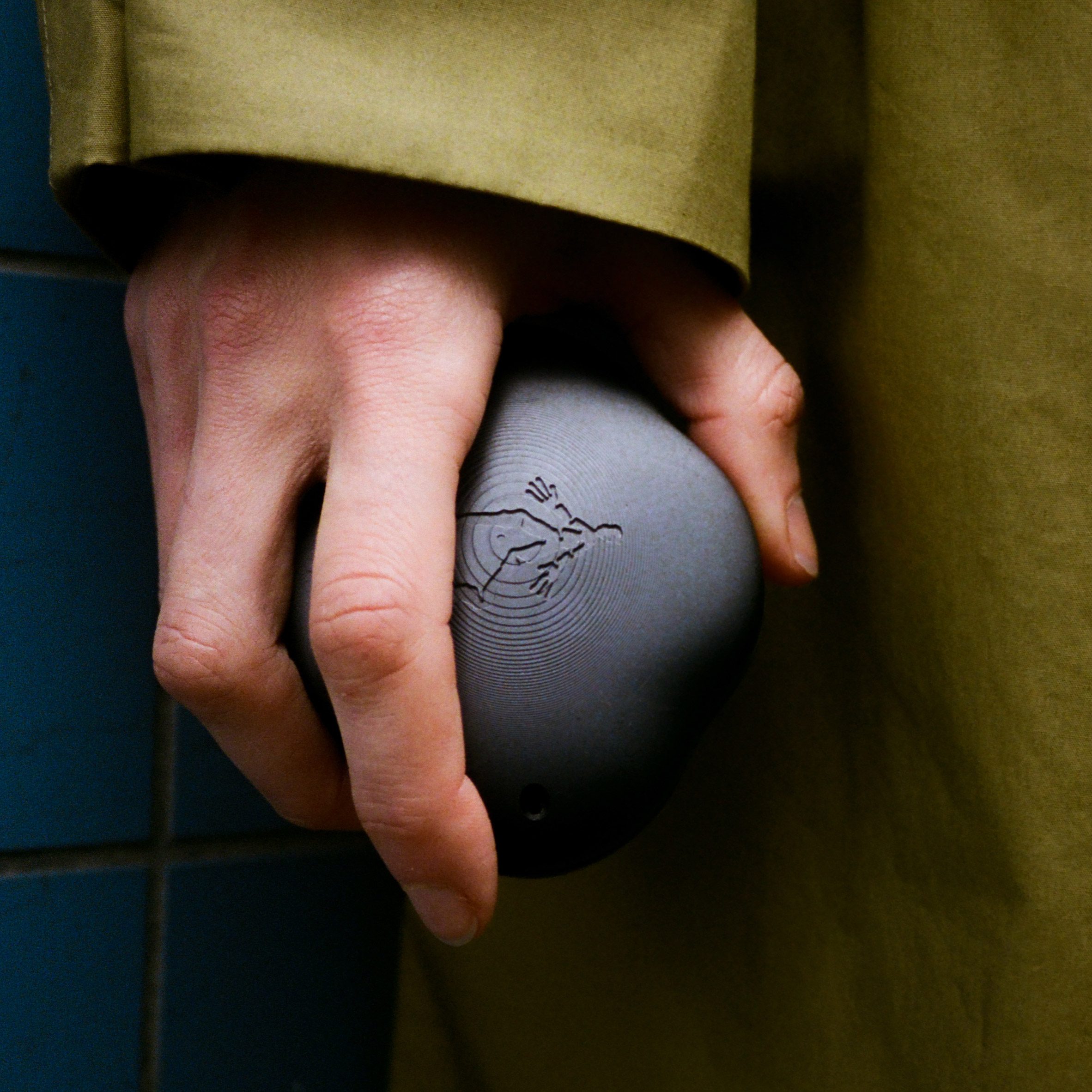 Close-up photo of a person's hand holding a smooth black Terra device