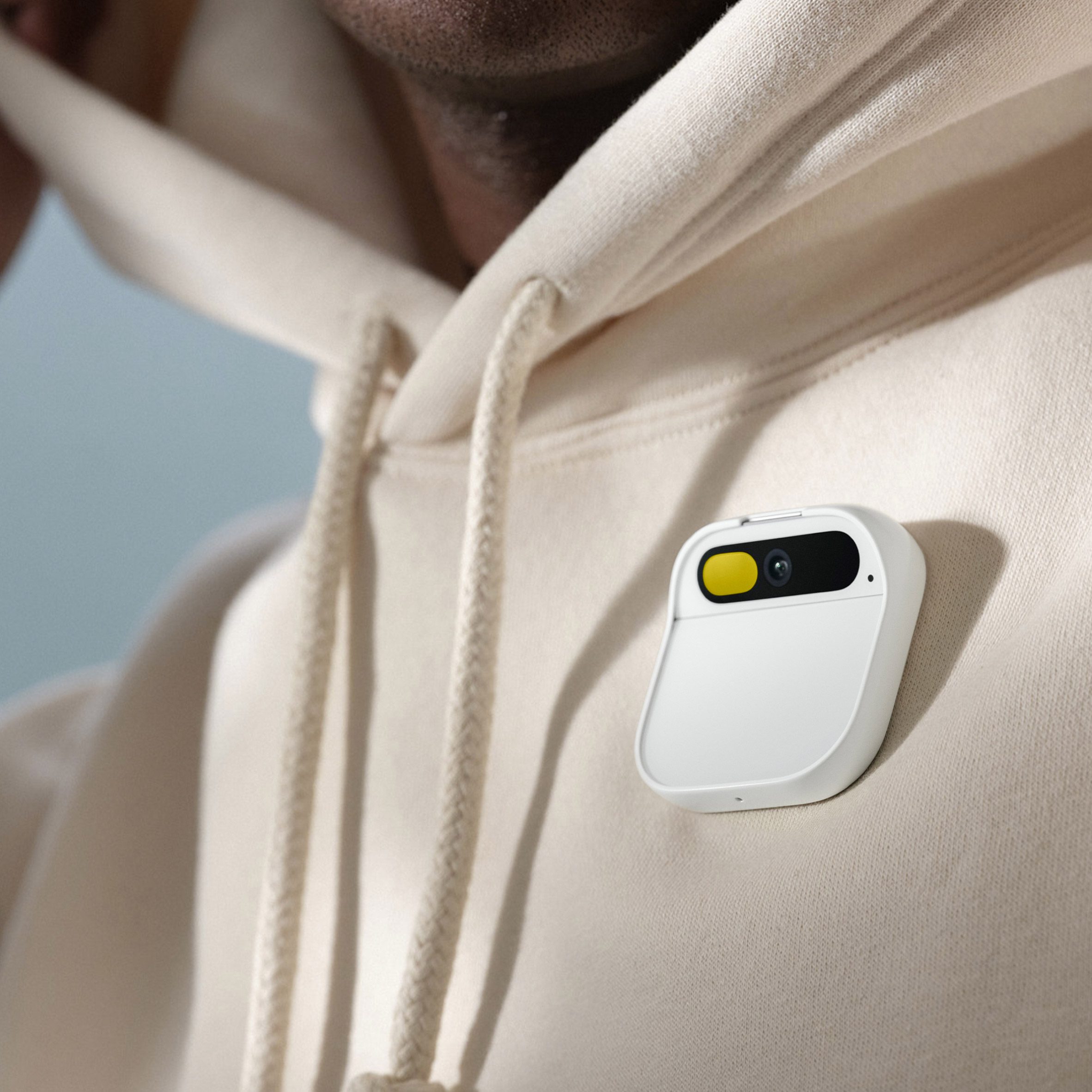 Close-up photo of a person's chest with the Humane AI Pin attached to their hoodie