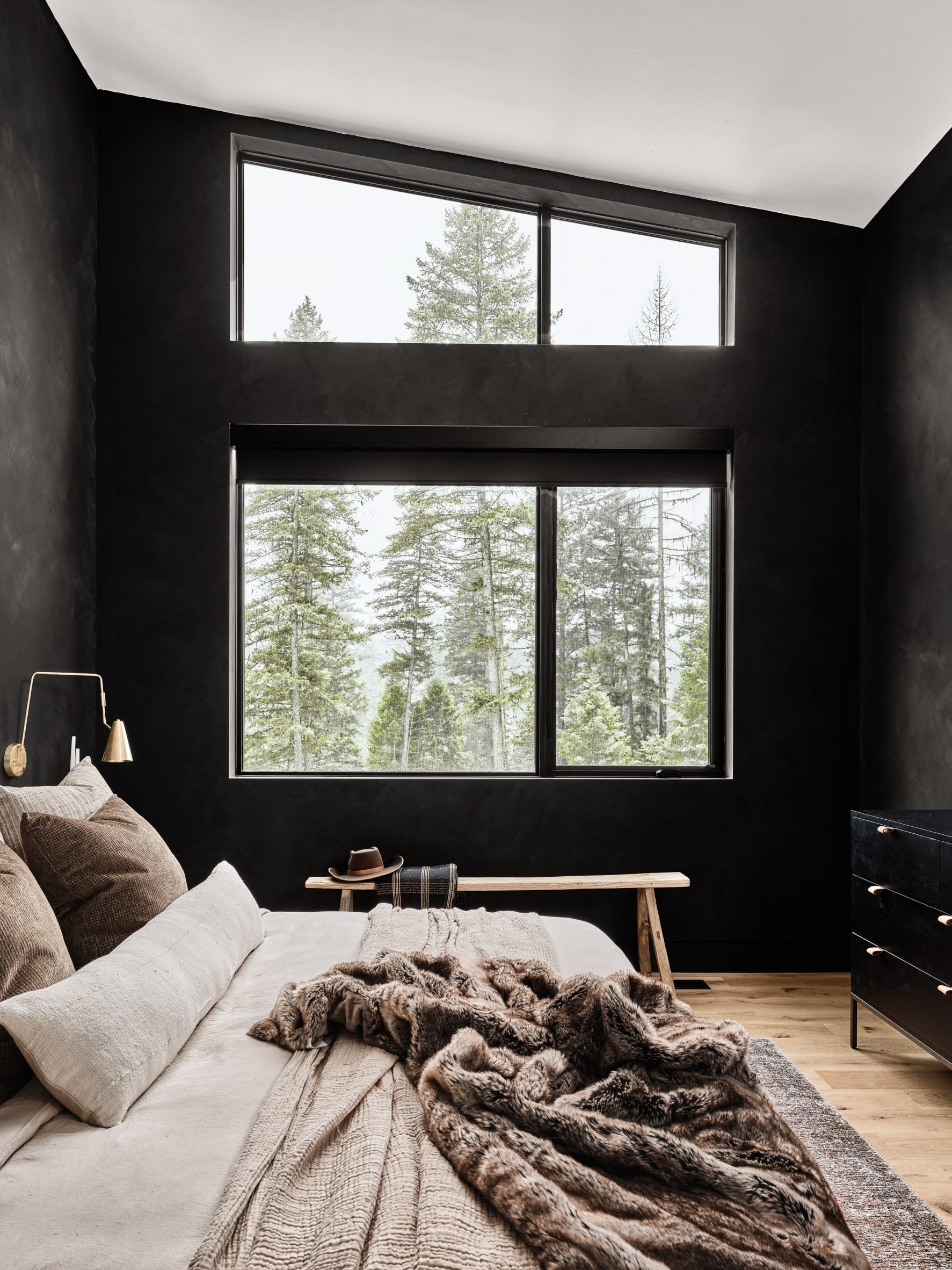 Bedroom with black walls and beige plush bedding