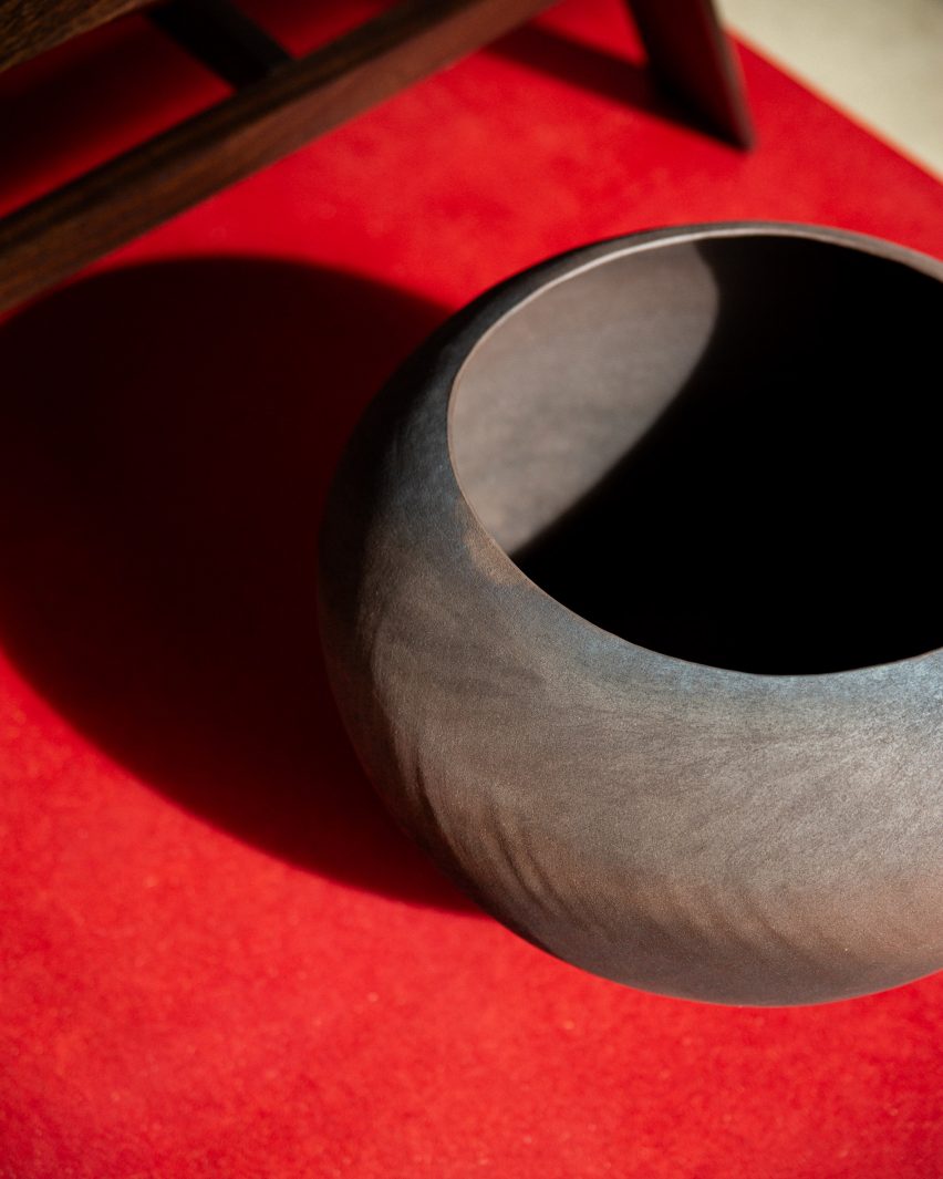 A photograph of a large brown steel bowl atop a red surface.