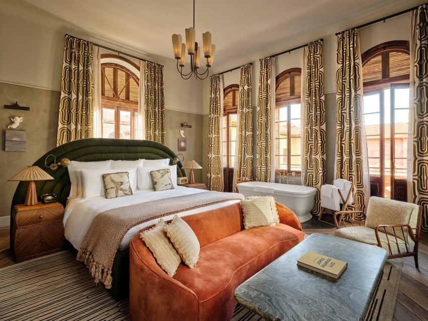 Guest bedroom featuring textured plaster walls and bold patterned curtains