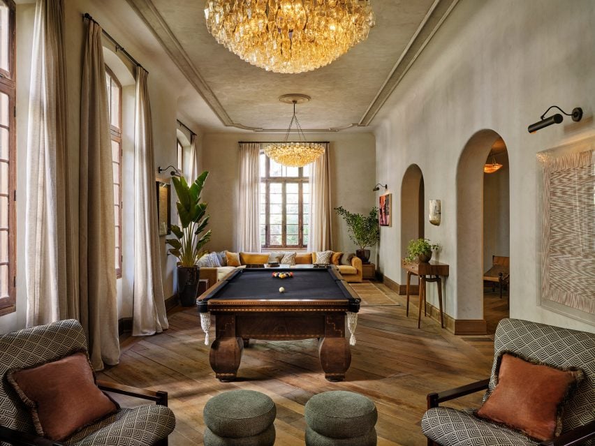 Games room with a pool table with navy blue top and a large yellow sofa 