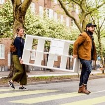 Two people carrying an IKEA cupboard