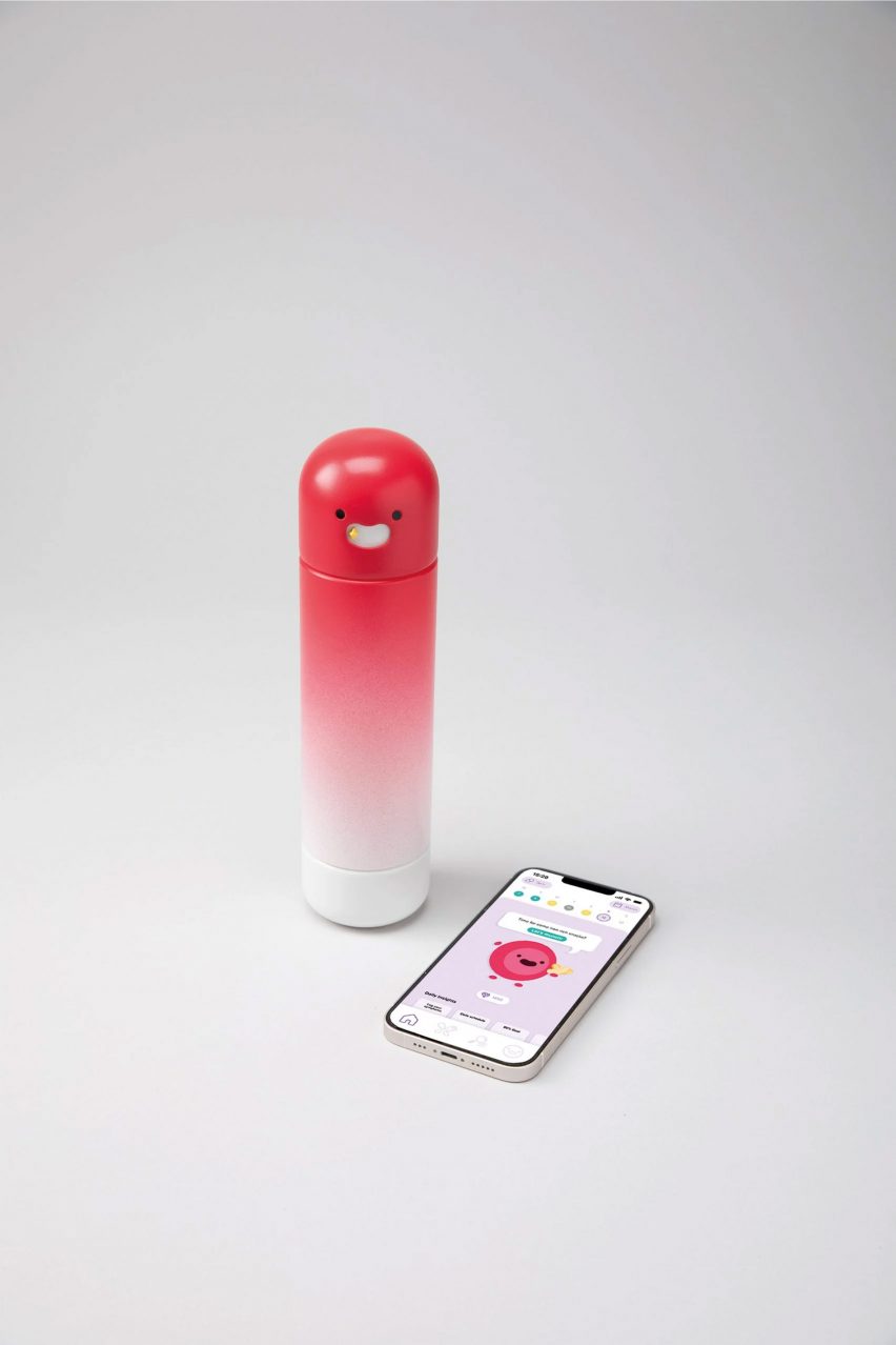 A photograph of a smartphone displaying a health management app in tones of pink and purple, with a pink water bottle beside it.